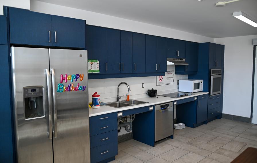 Kitchen with blue cabinets, letters on the fridge read Happy Birthday