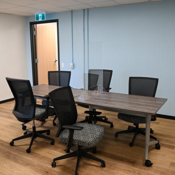 Meeting room with black chairs and a desk