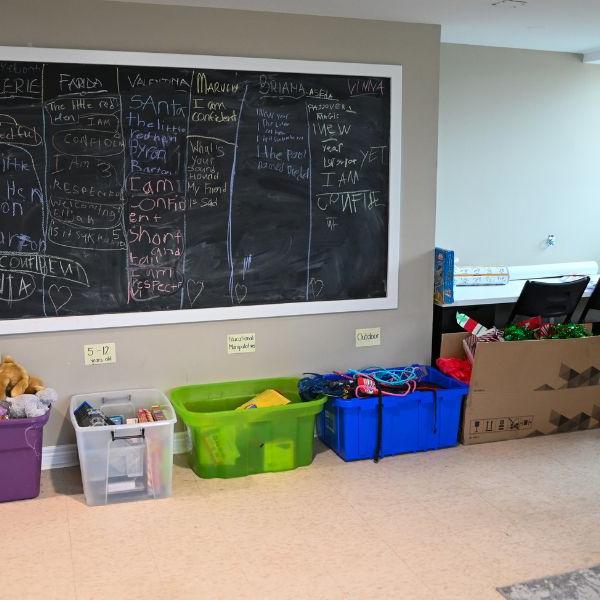Interior view of blackboard and bins of toys at Firgrove Grassways learning centre. 