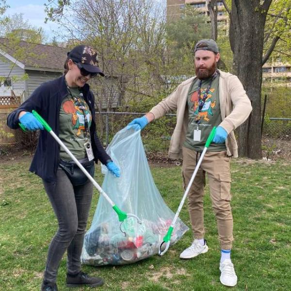 Two Conservation members picking up litter in a park.