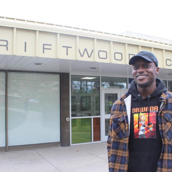 Man standing outside Driftwood Community Centre and smiling