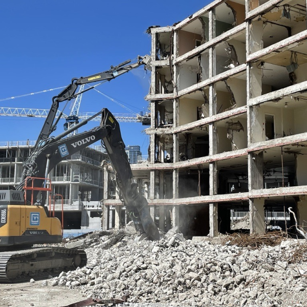 A crane removing building debris at a construction site in Regent Park