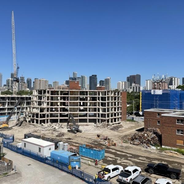 A wide shot of a construction site in Regent Park with a large building under demolition. 
