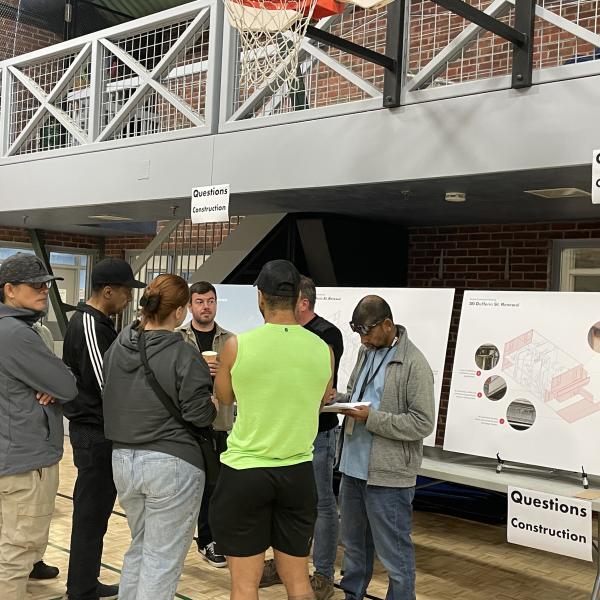 Tenants and staff at 300 Dufferin project meeting in front of poster boards