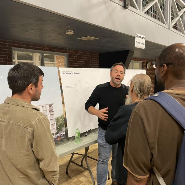 Crowd gathered around speaker at 300 Dufferin community meeting