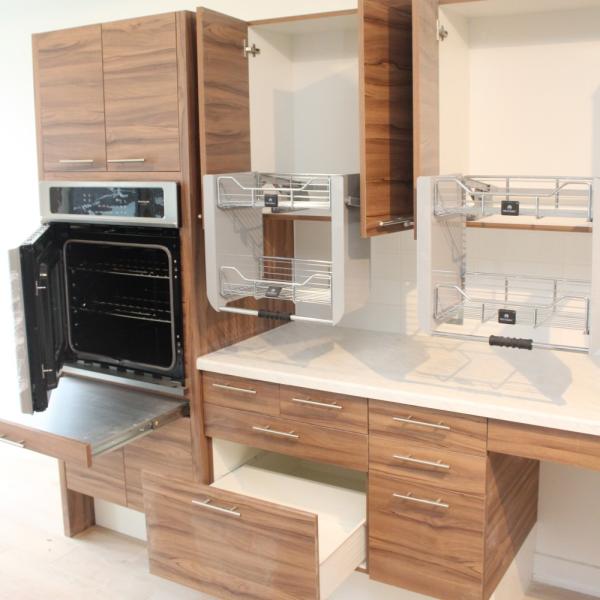 A unit kitchen showing cabinets, oven and countertop space with all of the doors open to show the inside.