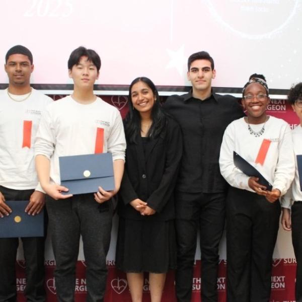 A group of students holding certificates and three other individuals smiling for a photo.