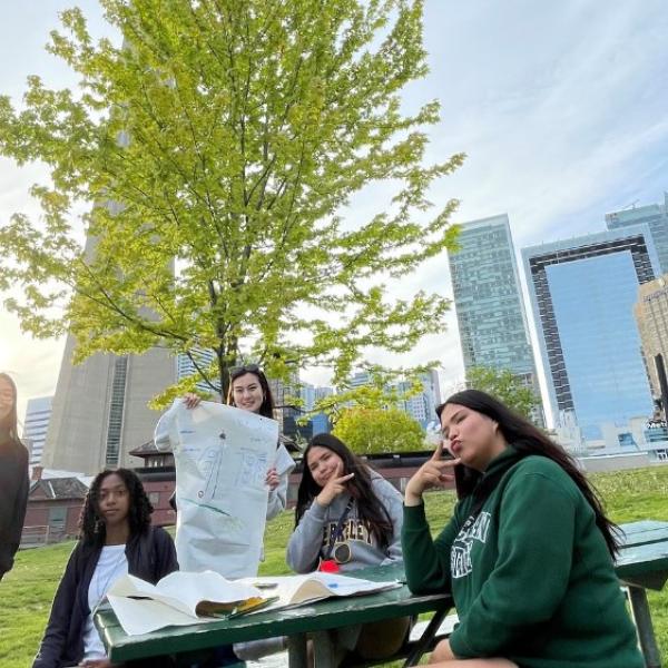 A group of youth participants sitting on a bench. The CN Tower is in the background.