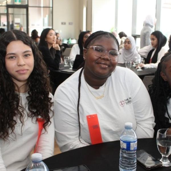 Three young women sitting at a table. 