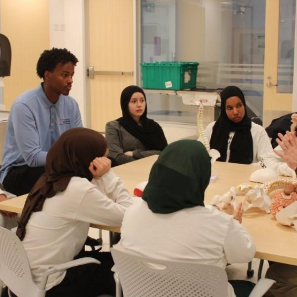 A group of people sitting around a table and having a conversation.