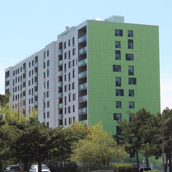 5 needle firway, a white apartment building with one green wall