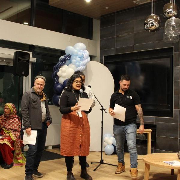 TCHC staff members standing in front of a microphone and giving remarks at an event inside 175 Oak Street.