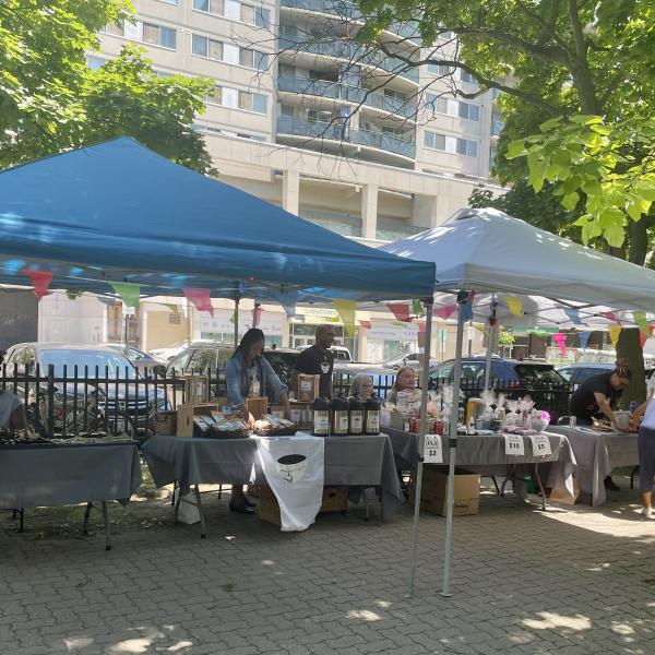 white and blue tents outside with tables at an outdoor marketplace
