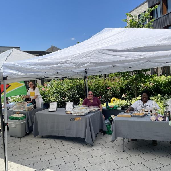 Three tables under a tent at an outdoor market