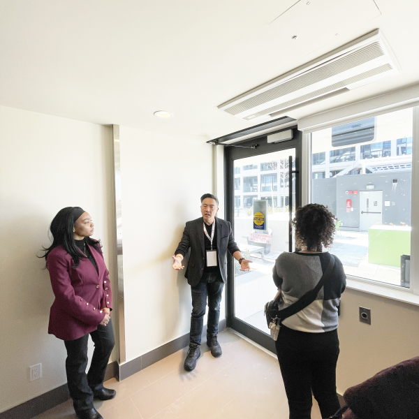 Three people touring the inside of a building.