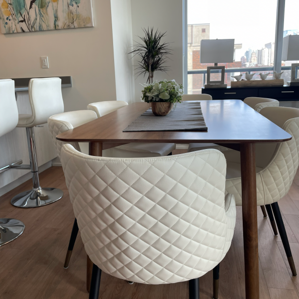 A dining room table with a vase of flowers on it.