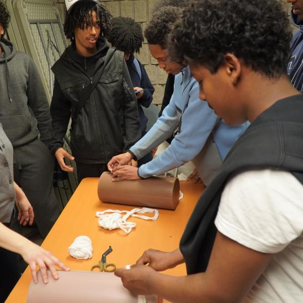 A group of youth standing around a table with first aid tools on it.