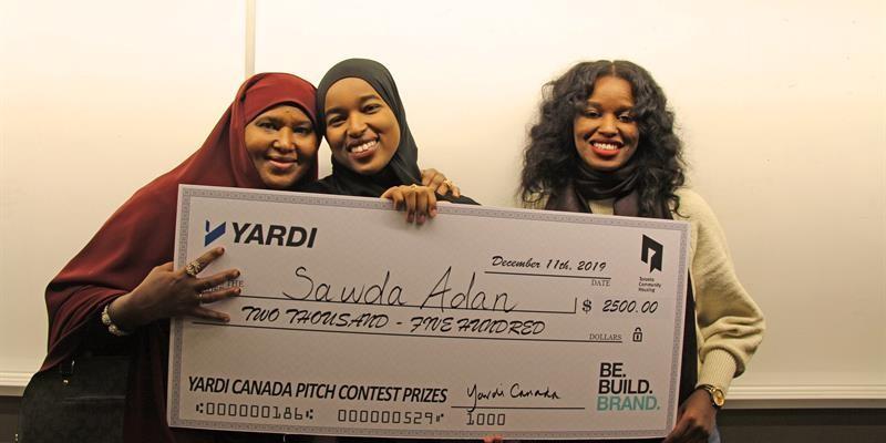 tenants pose with a giant cheque