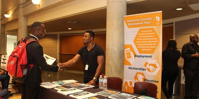 Staff member and tenant youth shaking hands