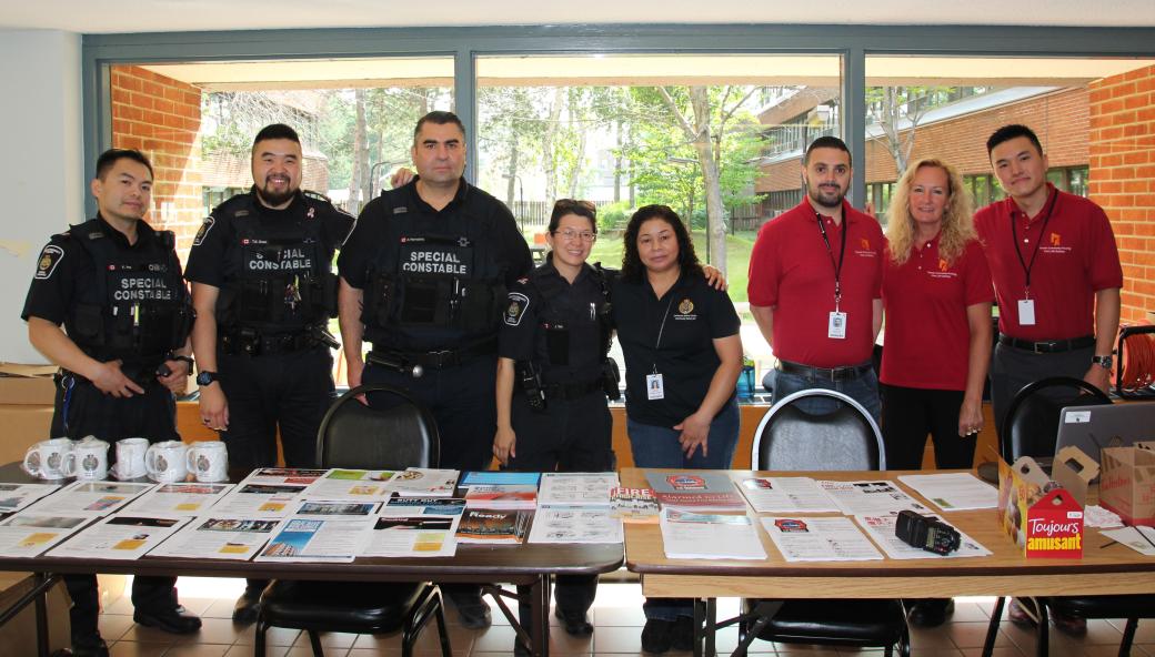 Group of TCHC staff standing at a long table with brochures on it