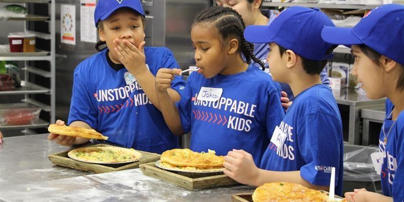 Group of tenant youth in a kitchen tasting pies