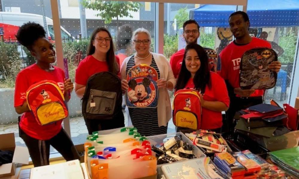 A group of people get ready to give children in the Leslie Nymark community school supplies for the upcoming school year