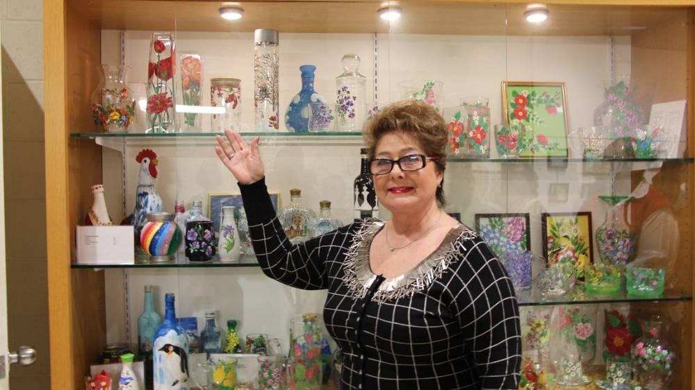 Liudmila Elistratova poses with a display of all the art pieces her classmates have created throughout the duration of the program.