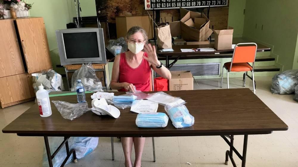 Volunteer packs disposable face masks for distribution to senior tenants in the Seniors Housing Unit.