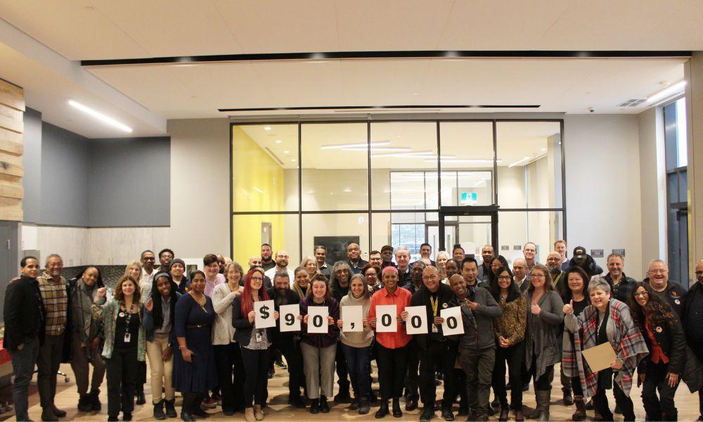 A group of TCHC employee volunteers hold a sign with $90,000 written on it, indicating the amount of money raised for United Way in 2023 A group of TCHC employee volunteers hold a sign with $90,000 written on it, indicating the amount of money raised for United Way in 2023