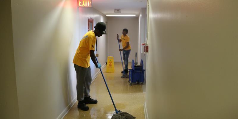 Tenant youth mopping a hallway