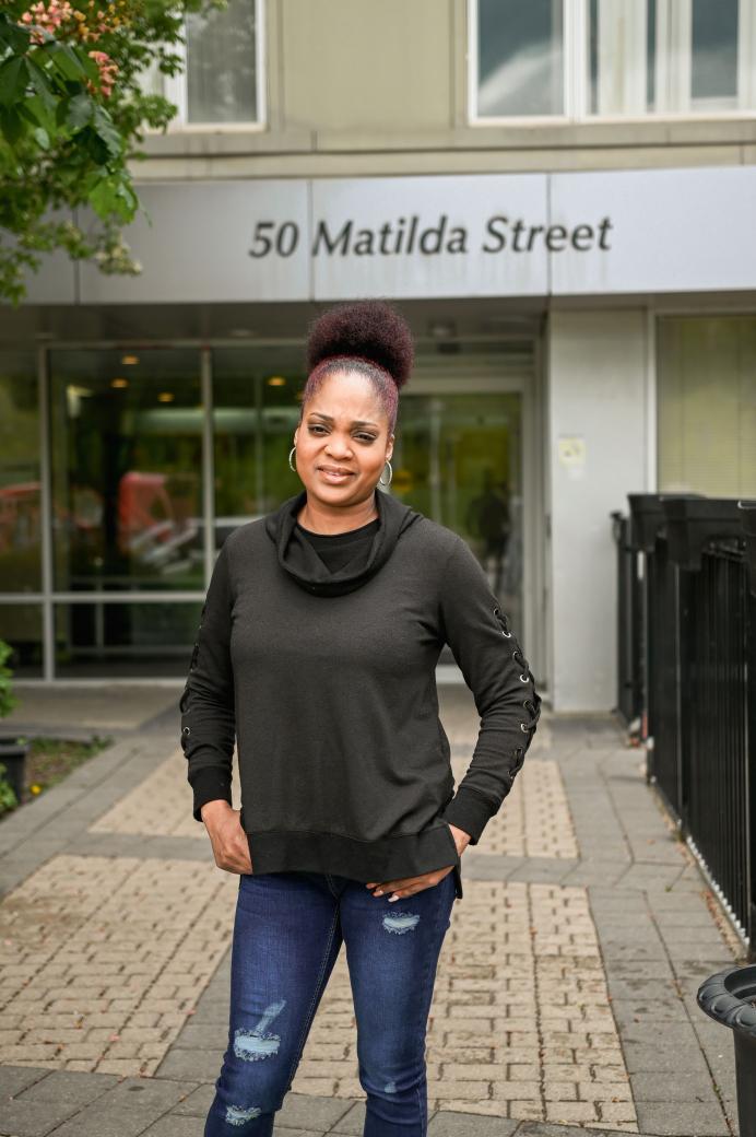 Tenant leader Suzette Saunders standing out front of a building in her rivertowne neighbourhood 