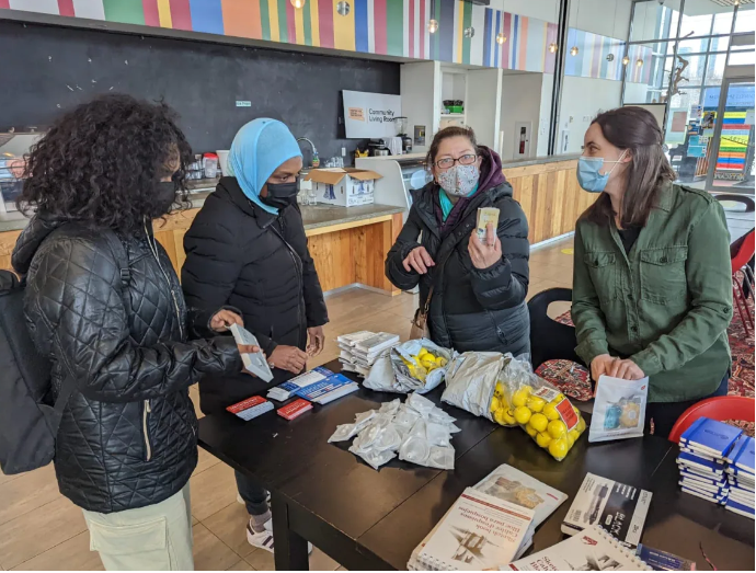 Group of people standing around a table at a mental health workshop