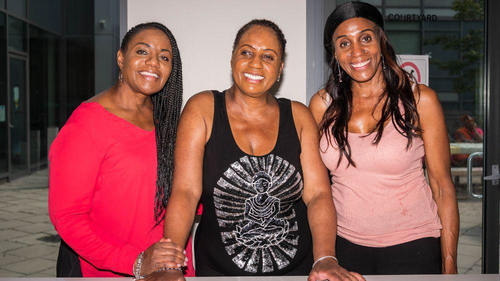 Karlene Nation and her two sisters Three women smiling for the camera.