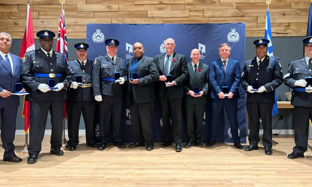 TCHC Community Safety Unit officers receiving medals and posing alongside Larry Shand and Tom Hunter.