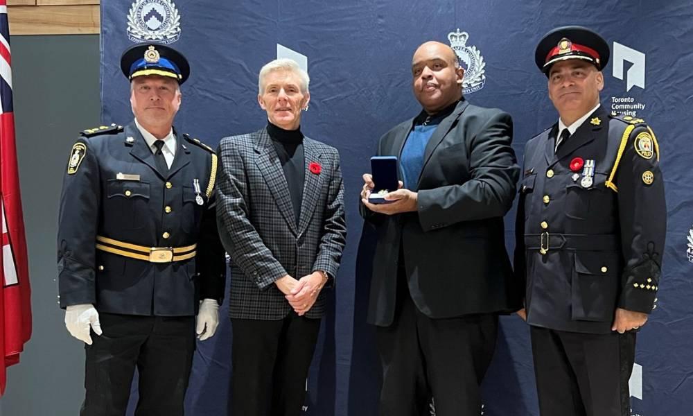 Allan Britton, Tom Hunter, Larry Shand and Deputy Chief Robert Johnson posing for a photo, while Larry holds his award.