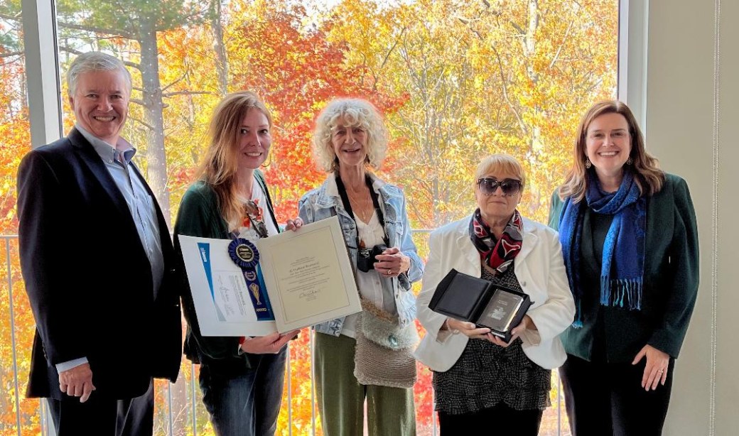 Group photo of people holding up an award plaque and certificate