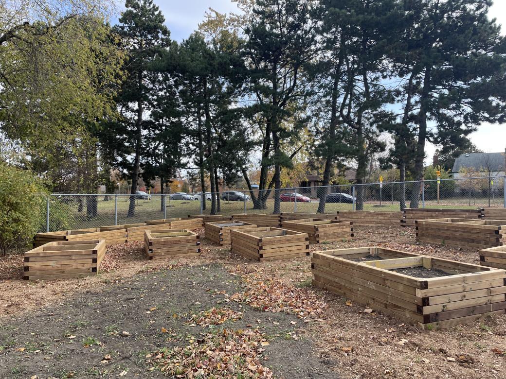 A group of outdoor plant beds in a wooded area 