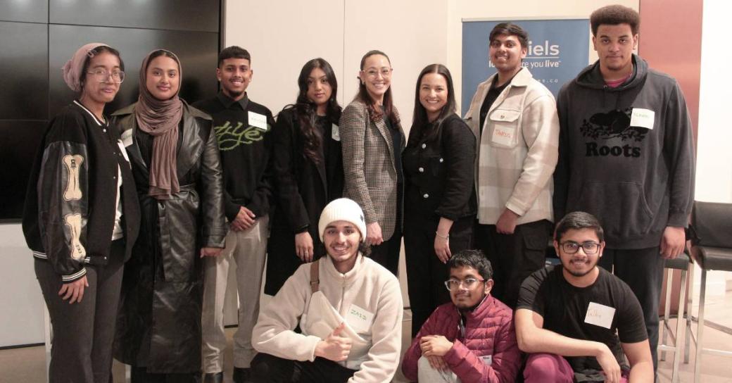 A group of 11 young people, who are part of the Moving Towards Opportunity program, wearing business casual clothing posing for a photo.