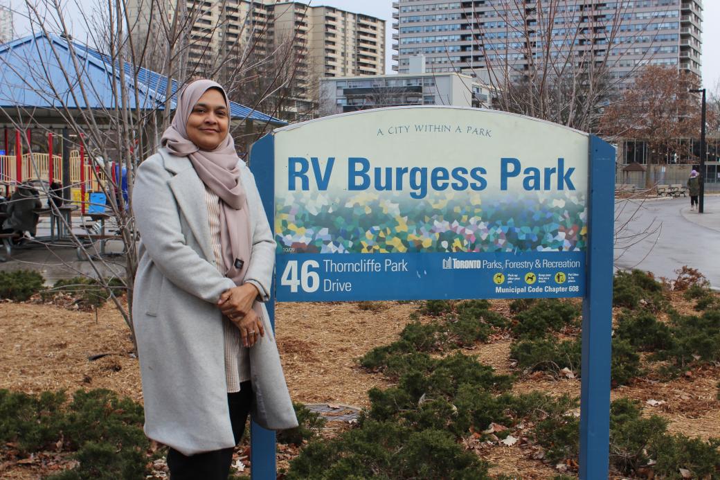 A person is standing in front of the RV Burgess Park sign
