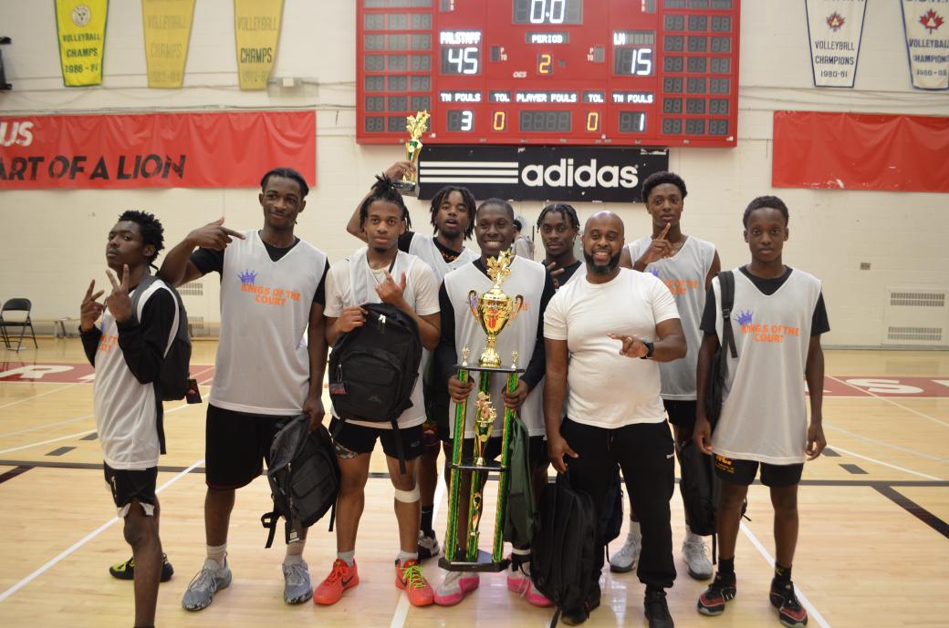 A group of people holding a trophy while posing for the camera. 