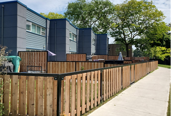 A backyard view of the newly rehabilitated TCHC units at 410 McCowan comprising of wood fencing used to separate four family units.