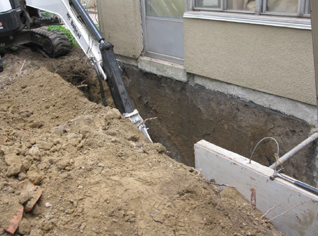 An excavation machine is used to dig and move earth at rear side of a TCHC building.