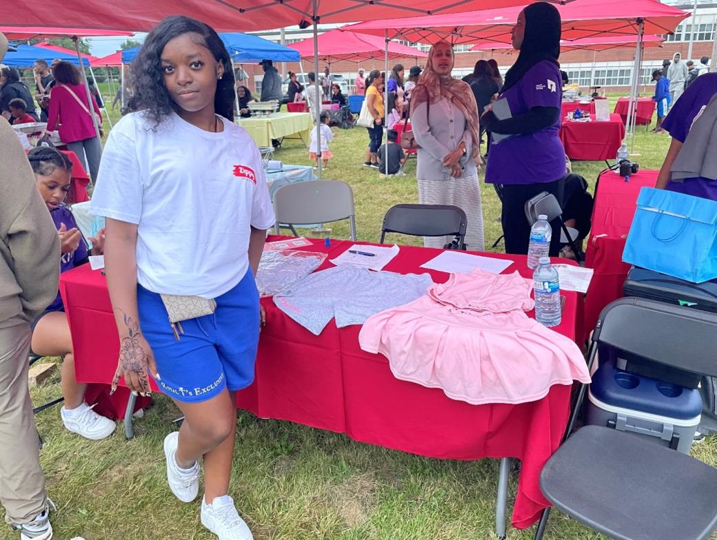 Treasure poses in front of a table displaying items from her clothing