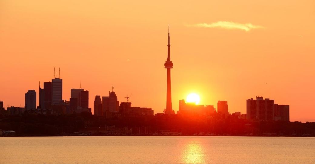 The Toronto city skyline with the sun rising on a hot day.