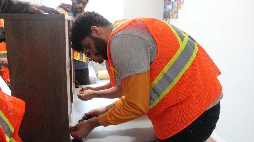 A photo of a man building a cabinet.