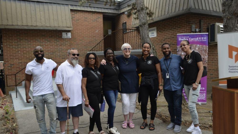 A group of people posing in front of a building