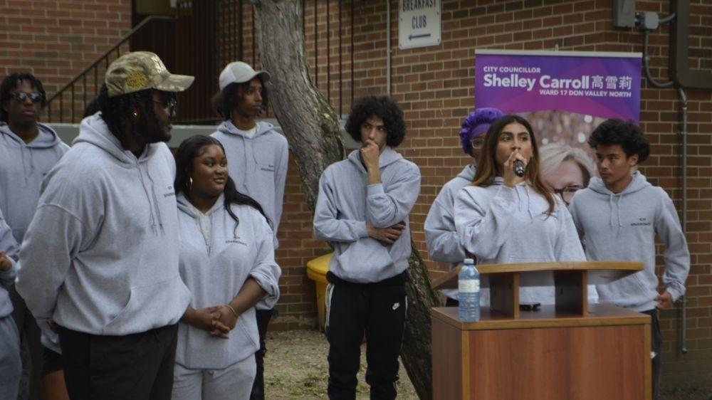A group of young people standing in front of a podium.