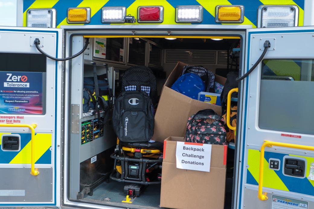 The back of an ambulance full of donated backpacks to give away