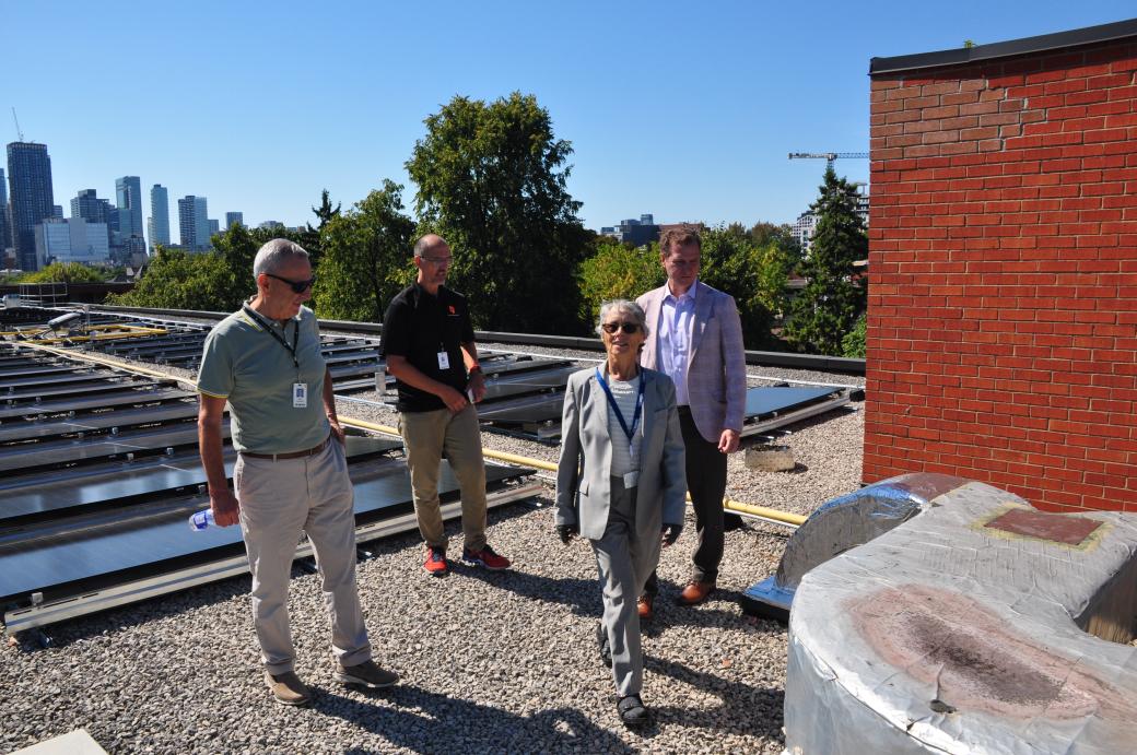 TCHC staff showing Councillor DIanne Saxe the solar panel retrofit on a rooftop