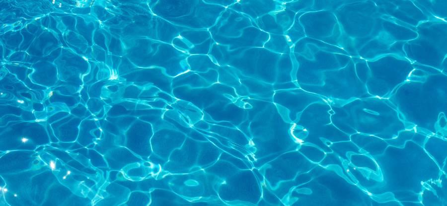 Close up of water in a pool with reflections from the sun.
